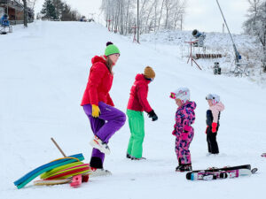 Instruktoři a děti při výuce lyžování